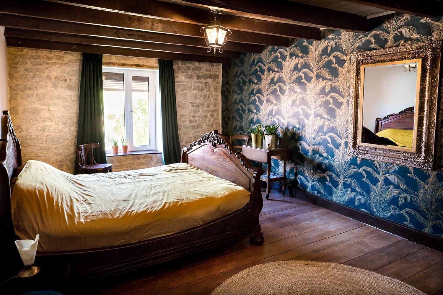 Slaapkamer met natuurstenen muur en palmbehang